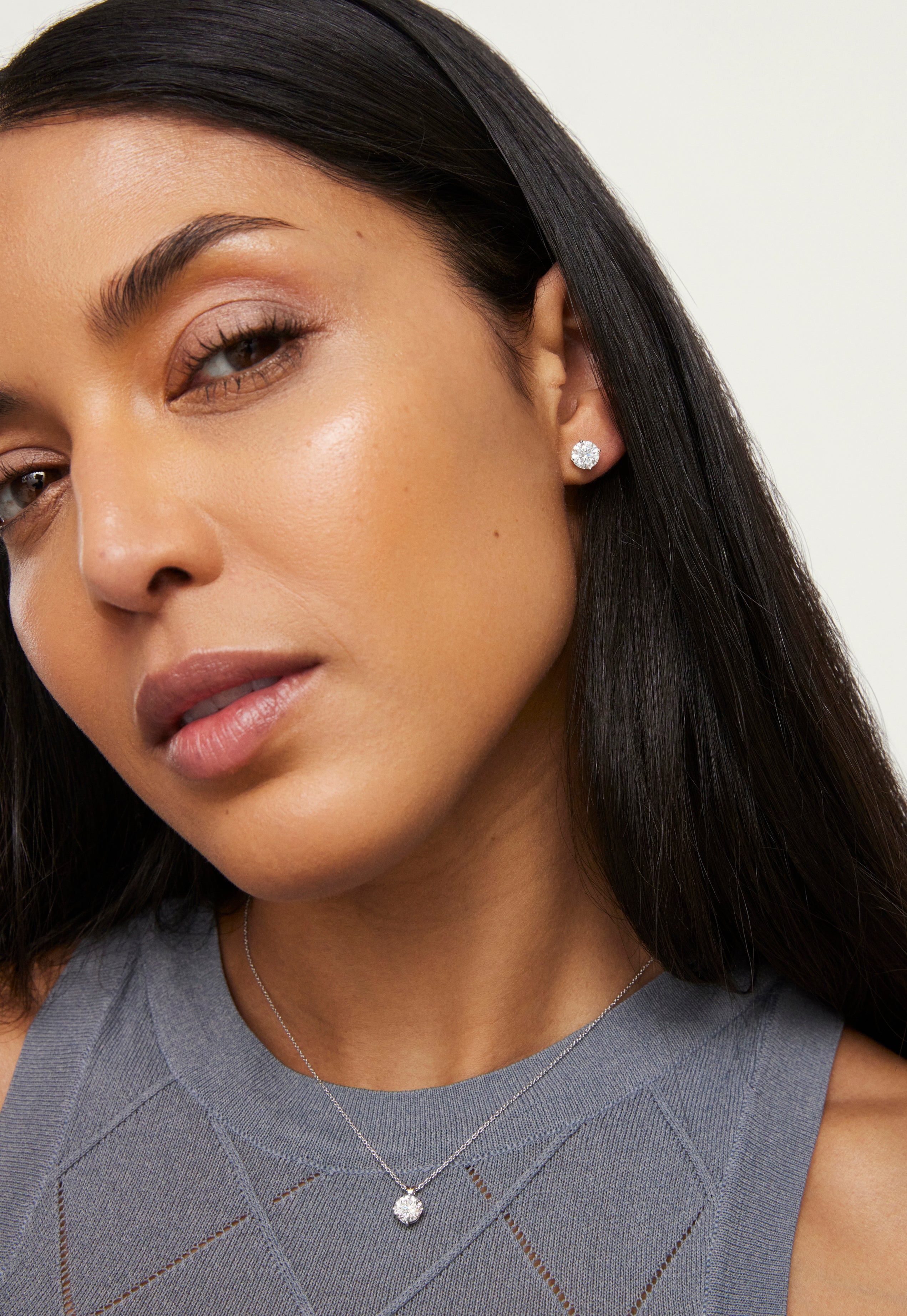 Woman wearing Lightbox Finest 1ct white round brilliant pendant and 1cttw round brilliant earrings