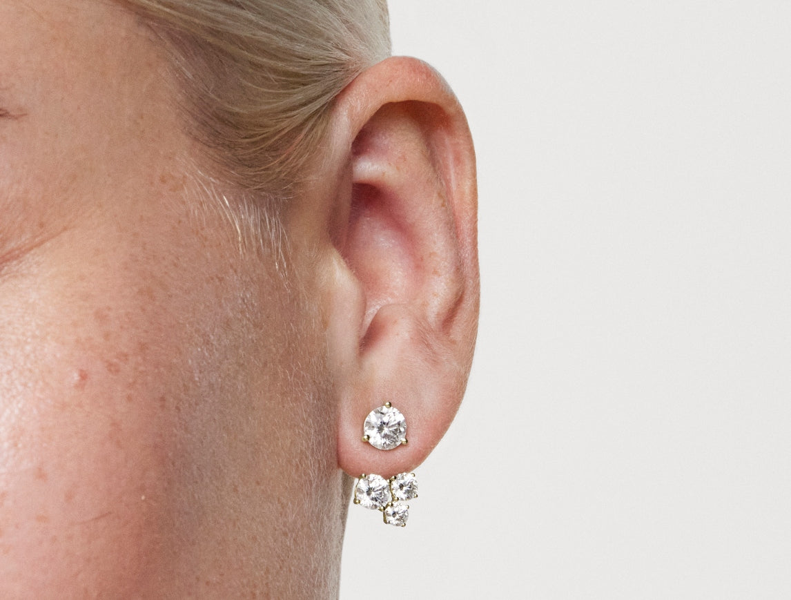 Close up model shot of 1.8 carat three stone earring jacket in 14k yellow gold with a 1ct round brilliant stud