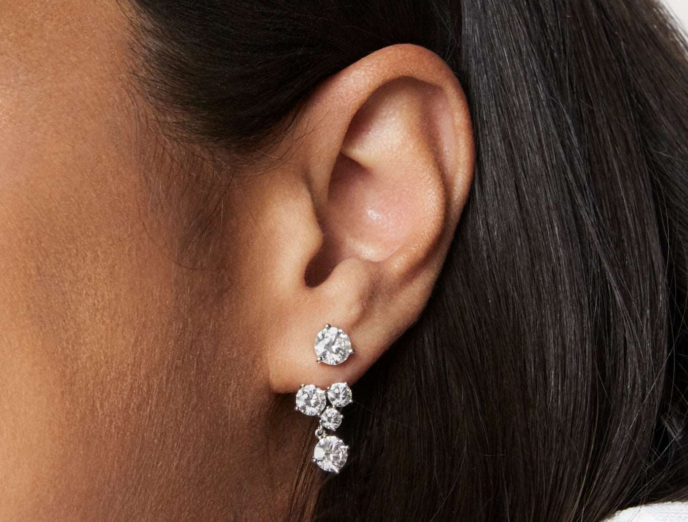 Close up model shot of 3.3 carat four stone earring jacket in 14k white gold with a 1 carat round brilliants solitaire stud
