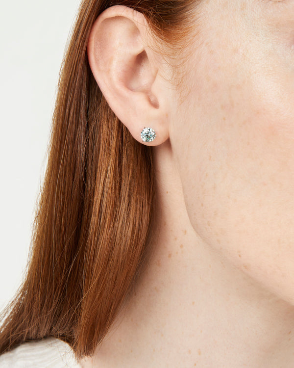 Model imagery of white gold, lab-grown blue 2 carat total weight round brilliant studs