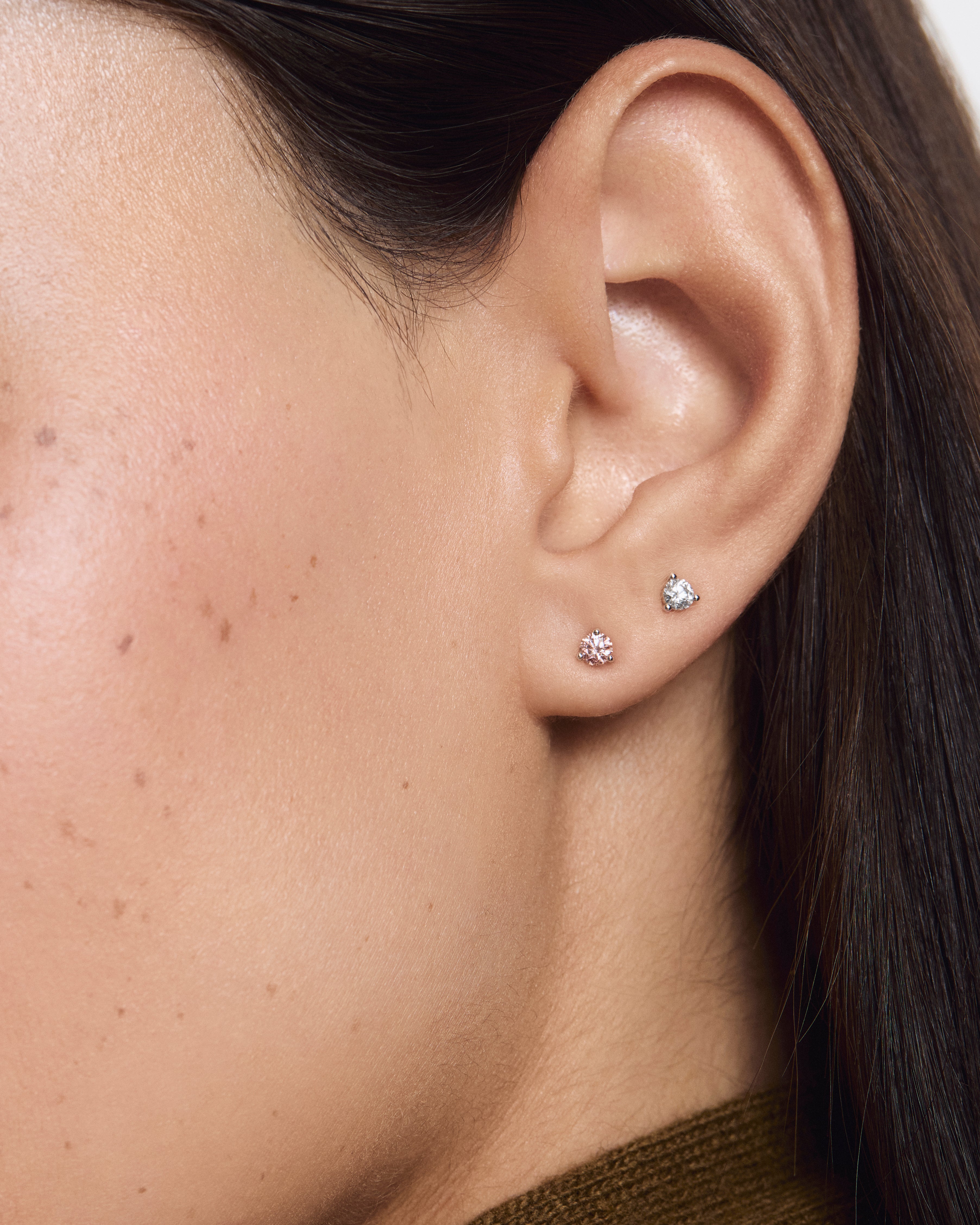 Model imagery of a ear stack containing  a pink mini round brilliant stud and a white mini round brilliant stud