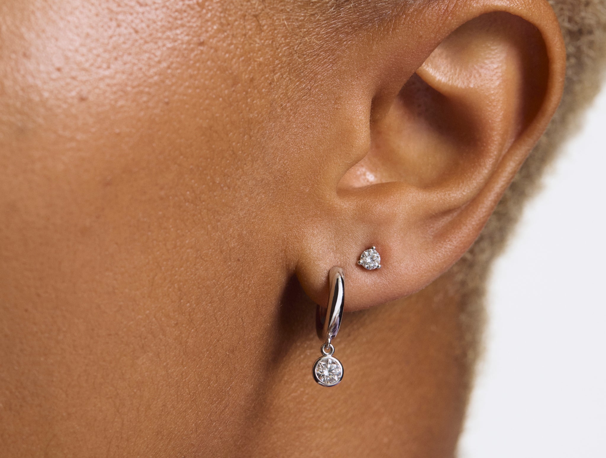 Model image of white gold wistful hoop earring stacked with a 0.125 carat stud