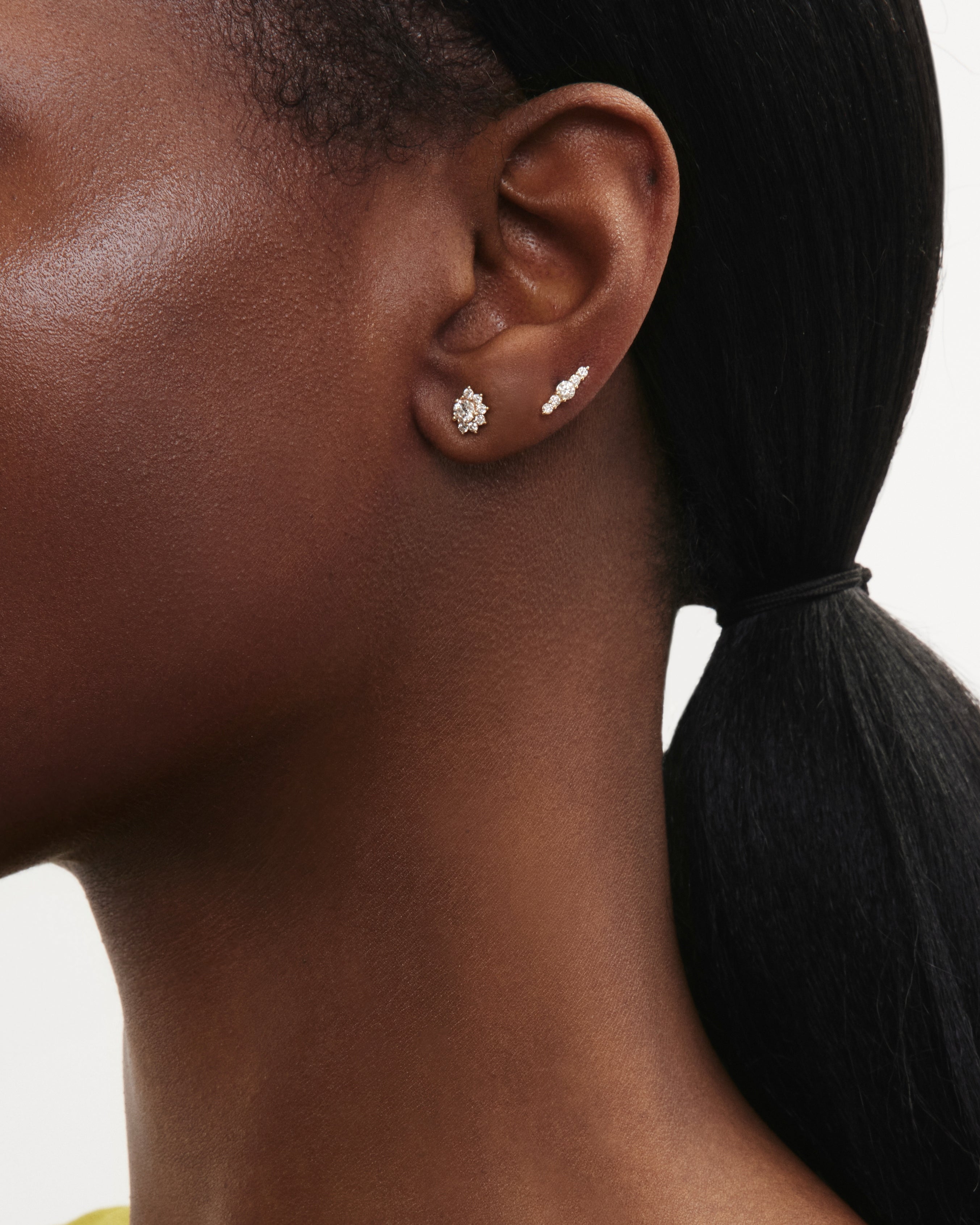 Model image of the mini sun beam earring and the mini line earring in yellow gold