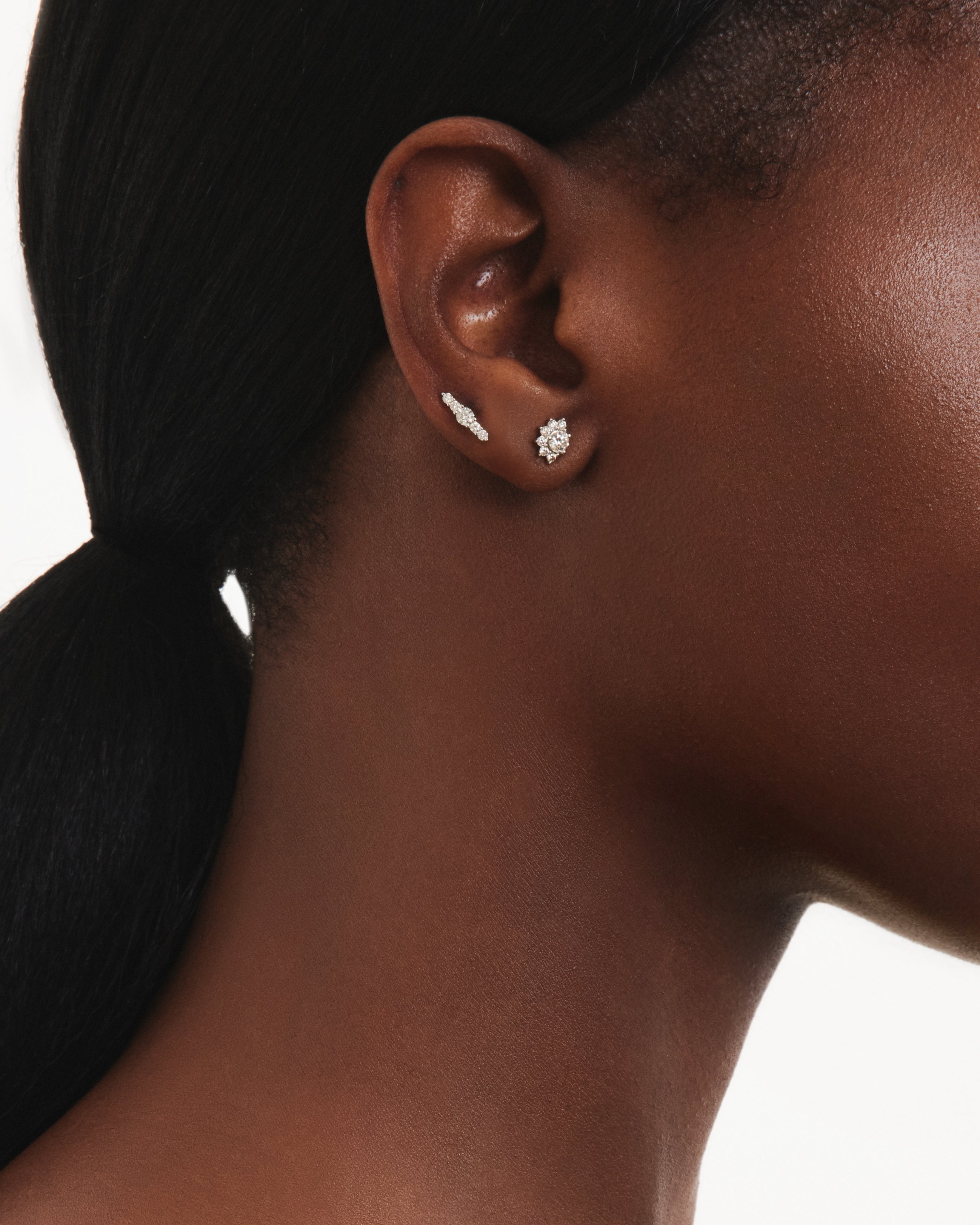 Model image of the mini sun beam earring and the the mini line earring in white gold