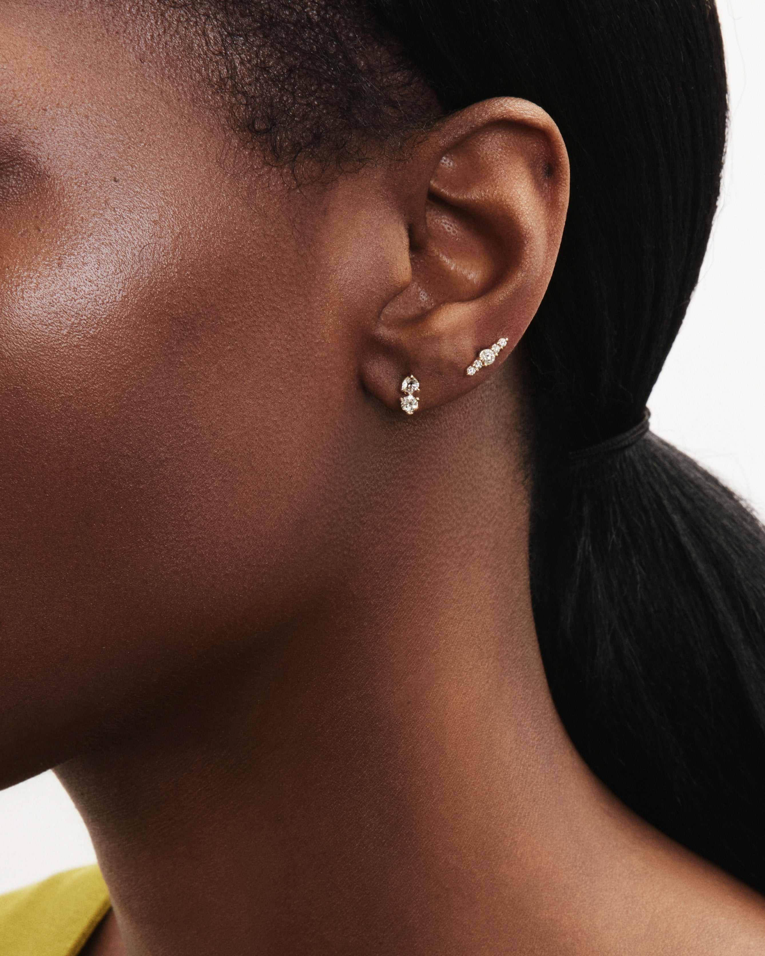 Model image of the mini line earring and the mini double drop earring in yellow gold