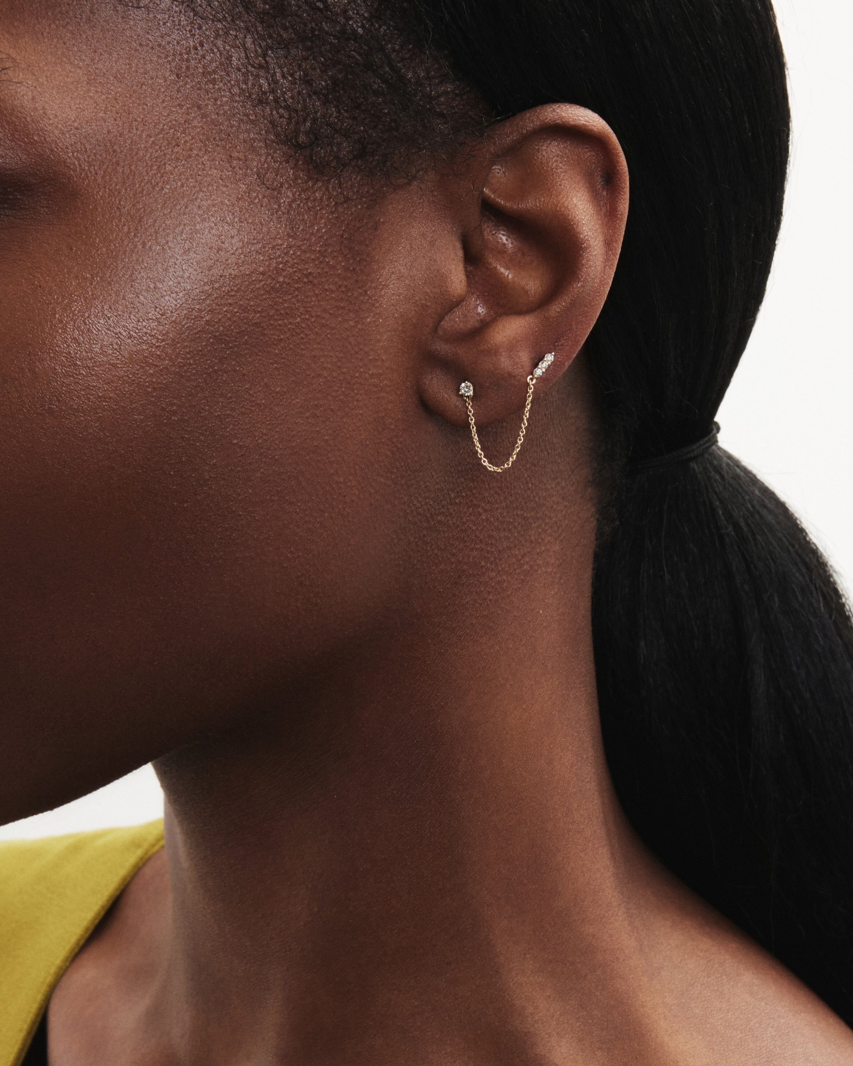 Model image of the mini double stud chain earring in yellow gold