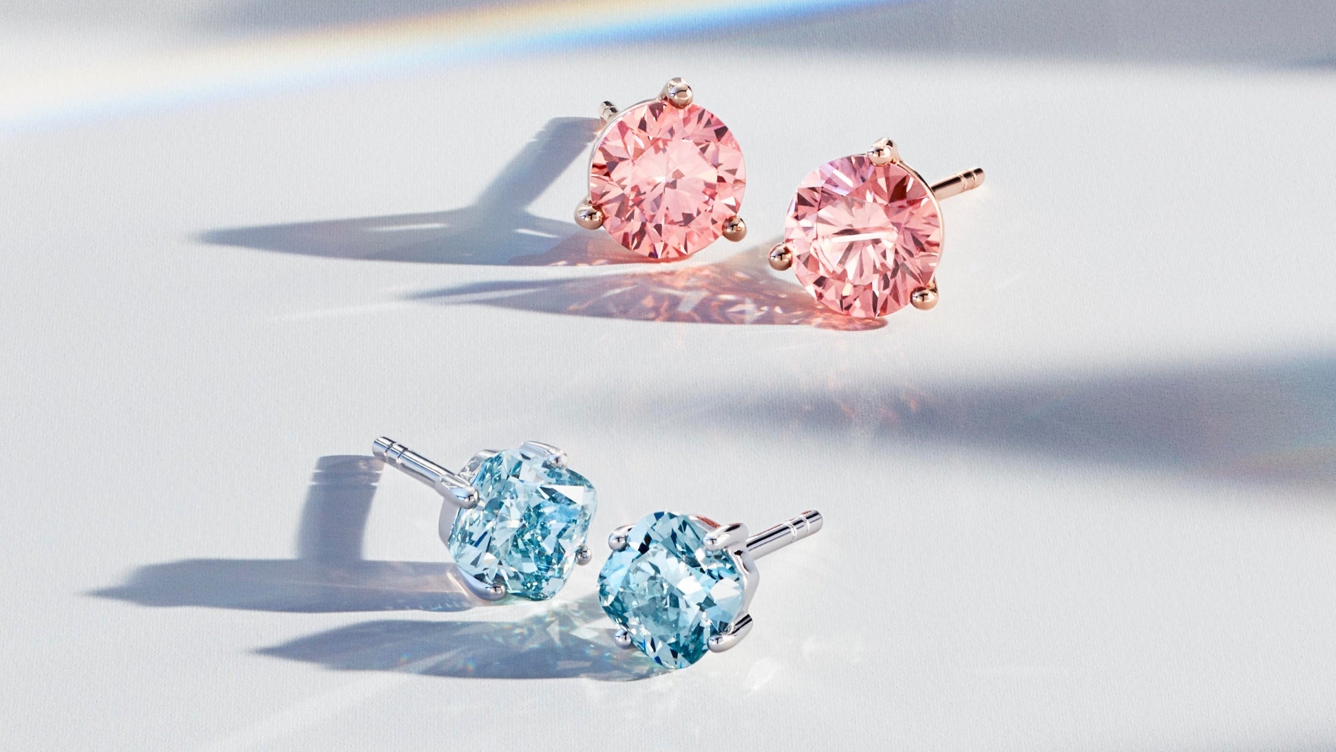 Pink and blue of lab-grown diamond studs in blue cushion cut and pink round brilliant cut