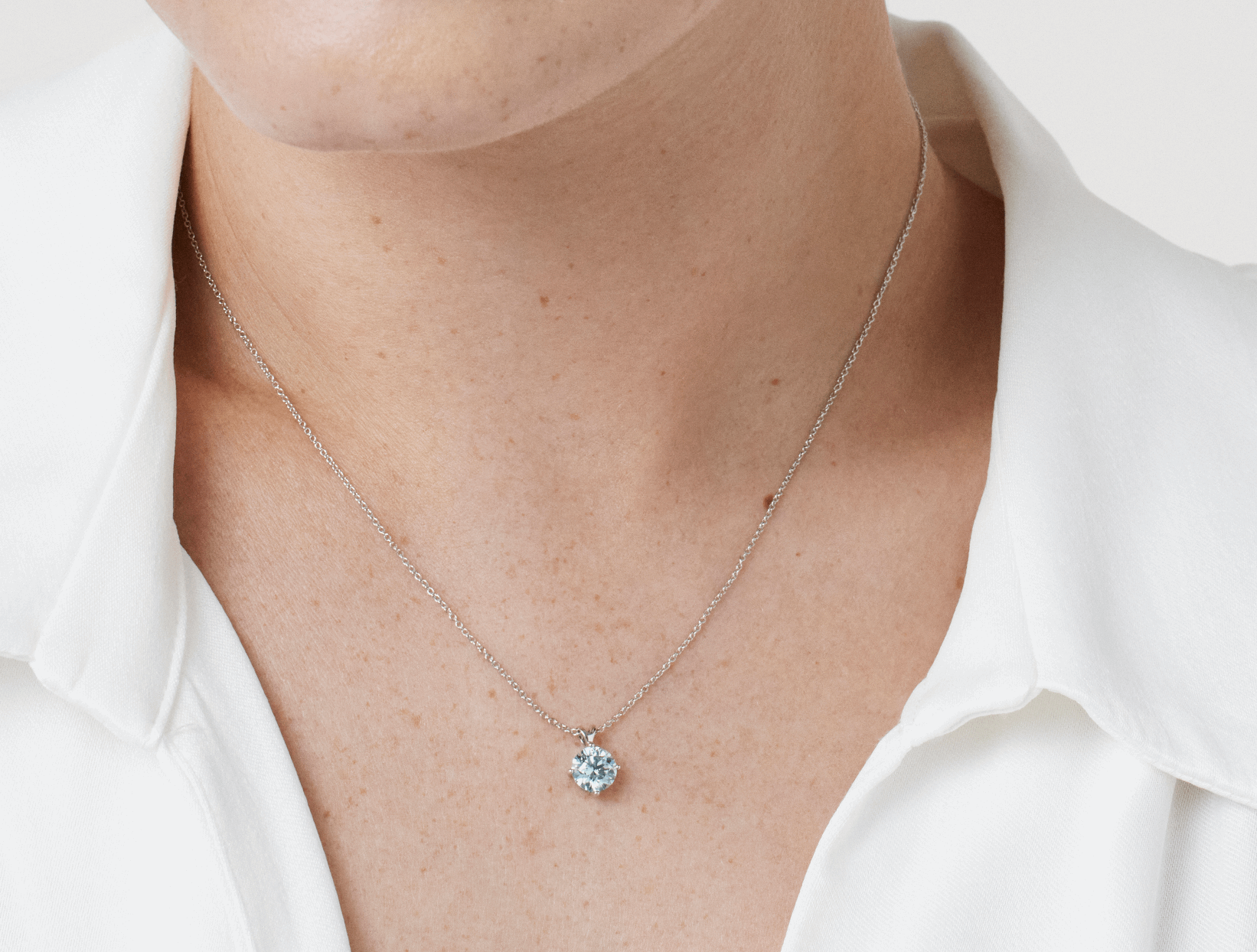 Close up model shot of Lightbox Finest™ 1 carat blue solitaire pendant in 18k white gold