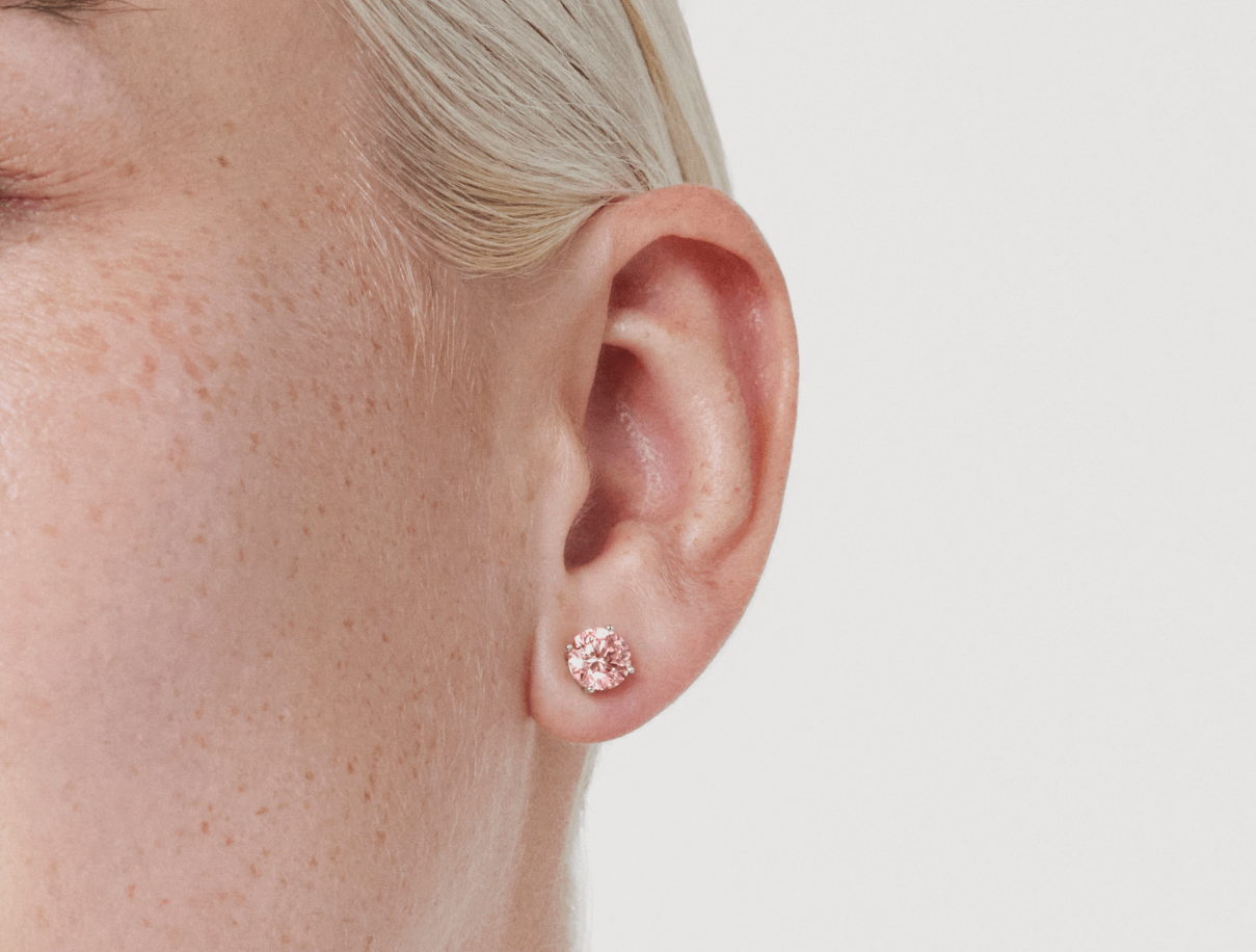 Close up model shot of Lightbox Finest™ 2 carat total weight pink round brilliant solitaire studs in 18k white gold