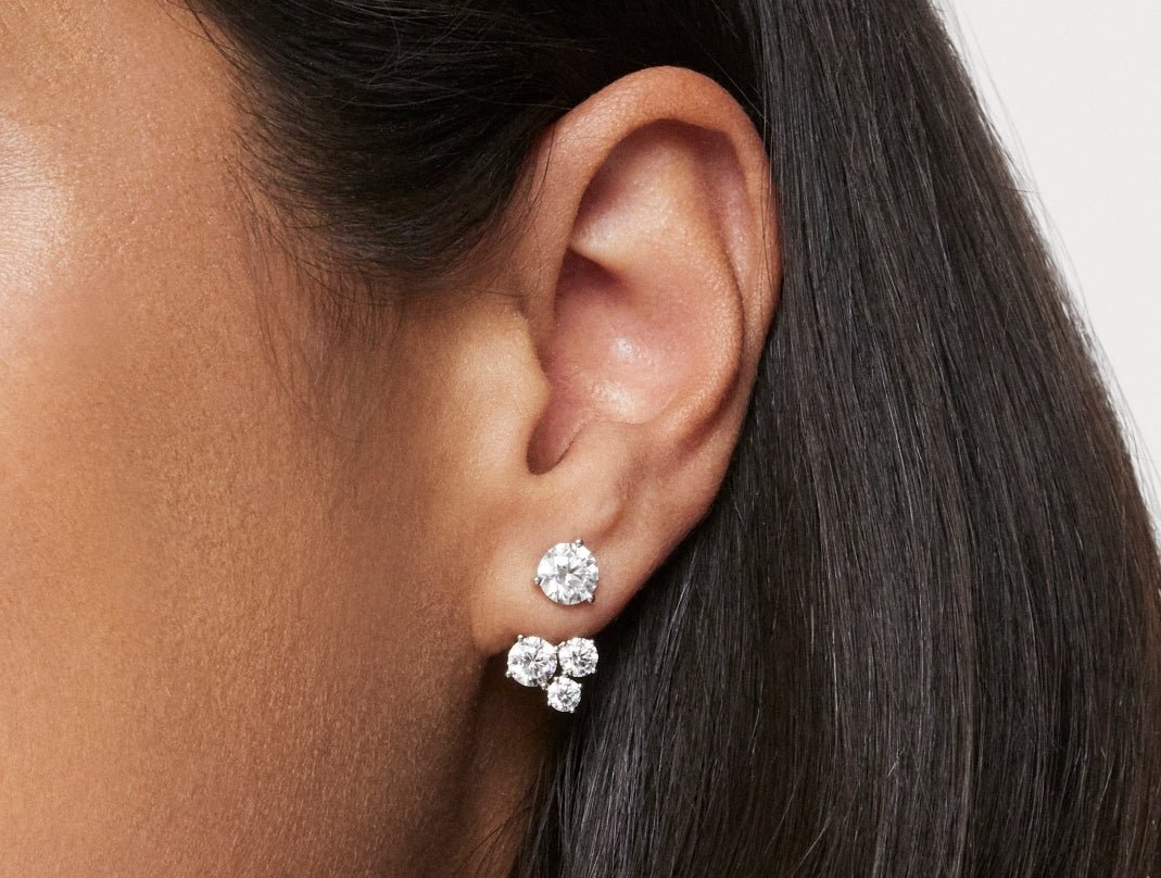 Close up model shot of 1.8 carat three stone earring jacket in 14k white gold with a 1ct round brilliant stud