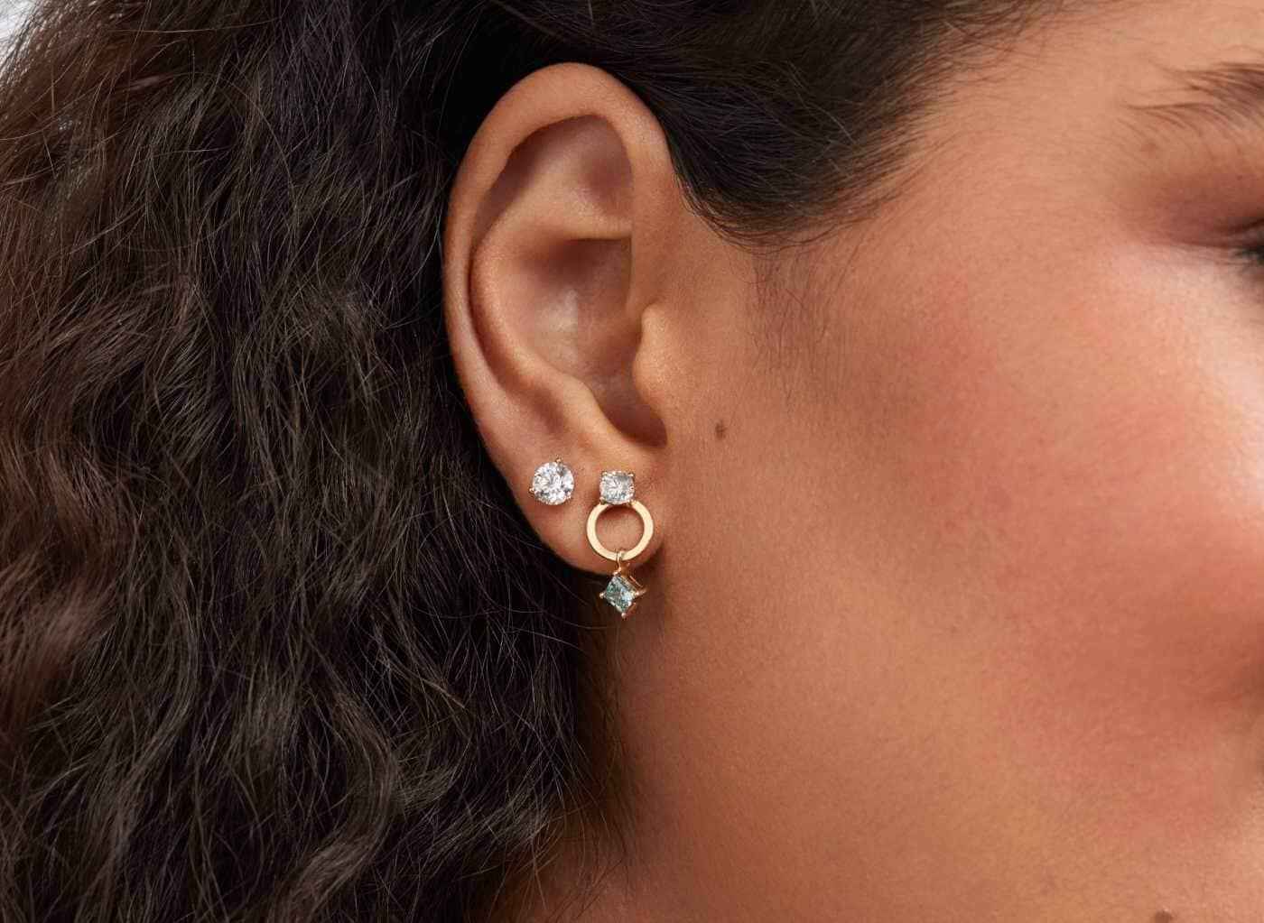 On model view of Solitaire 1 carat earrings with white diamonds in 10k yellow gold